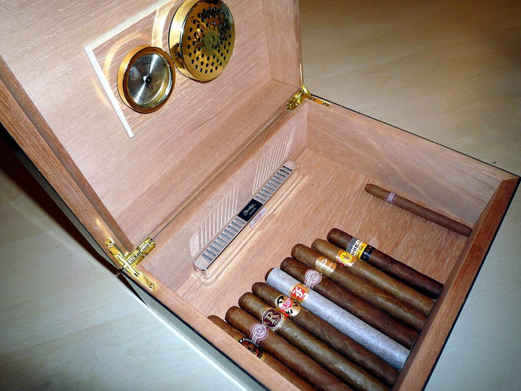 Bên trong hộp humidor gỗ tuyết tùng với đồng hồ đo ẩm và bộ tạo ẩm trên nắp